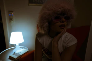 Pinky sitting alone in a dimly lit room, surrounded by betting slips and empty bottles.