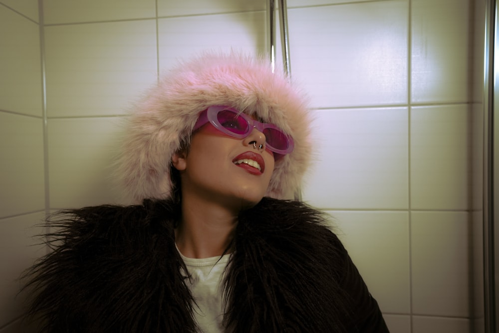 a woman wearing a fur hat and sunglasses