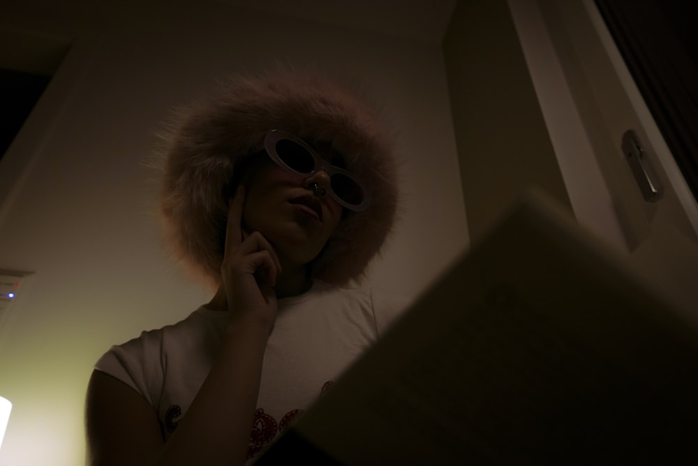 una donna che indossa un cappello di pelliccia e occhiali da sole che parla al cellulare