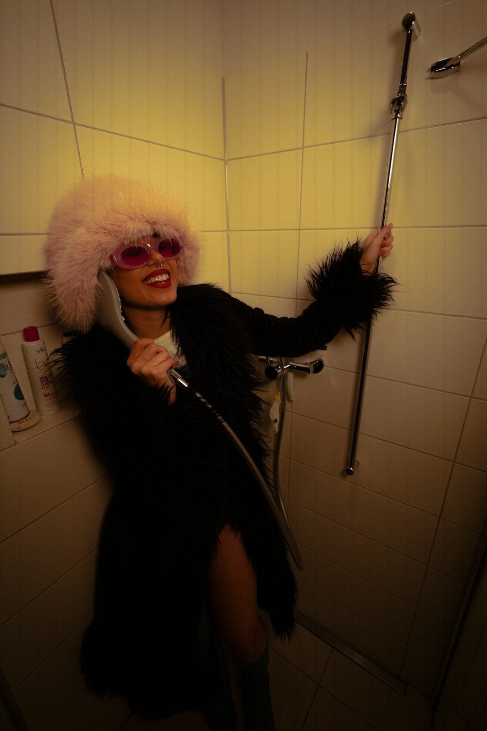 a woman in a bath room holding a shower head