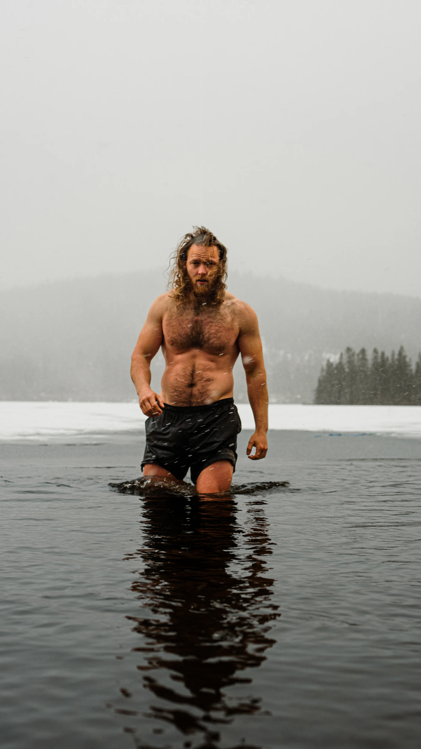 A person standing in a cold outdoor body of water