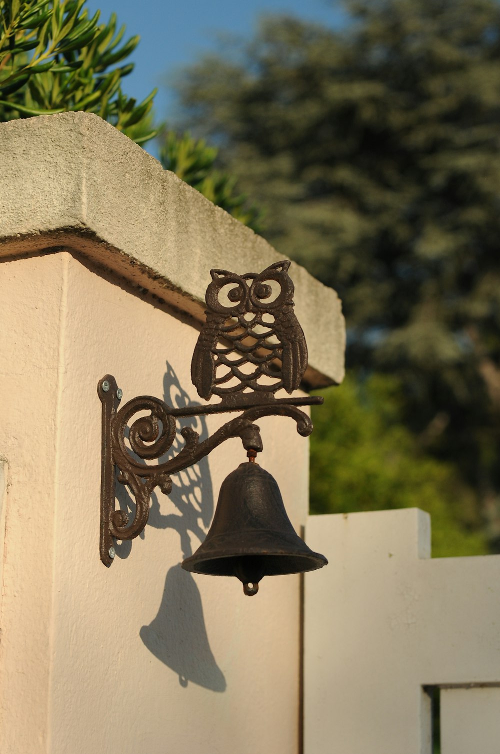 Une cloche avec un hibou dessus est attachée à un mur