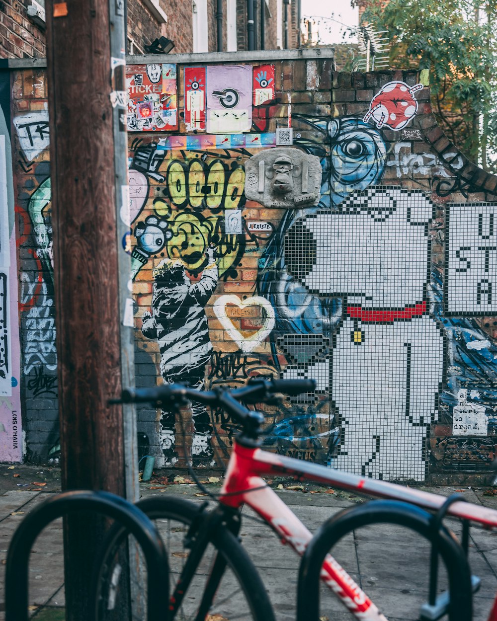 a bicycle parked in front of a graffiti covered wall