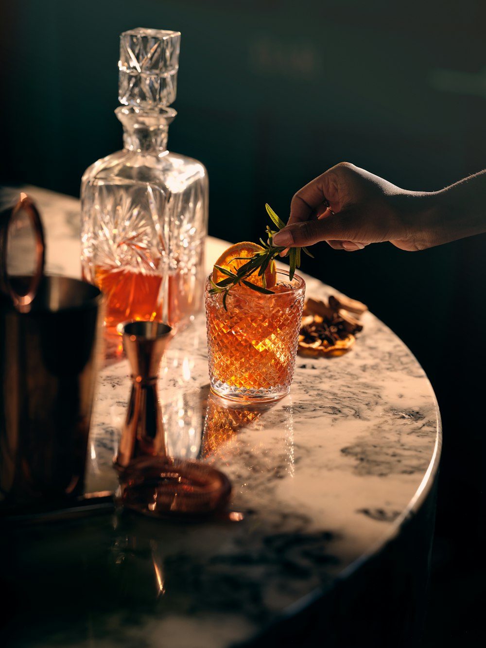 a person holding a piece of food in front of a glass