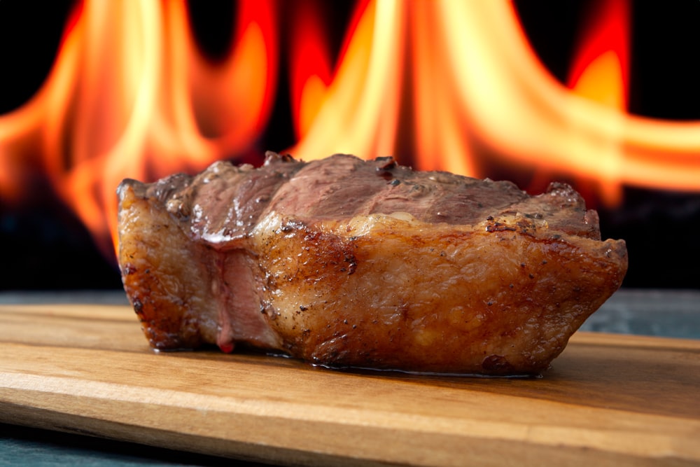 a piece of meat sitting on top of a wooden cutting board