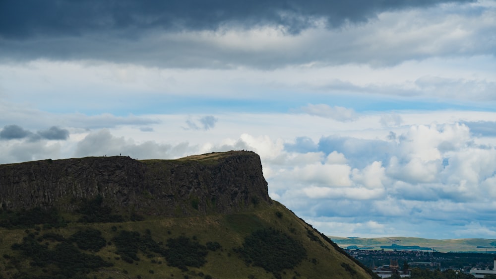 une grande colline avec un ciel rempli de nuages