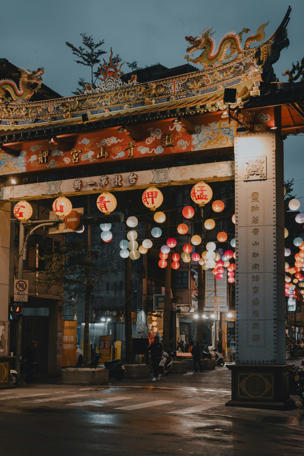 a chinese gate with lanterns hanging from it