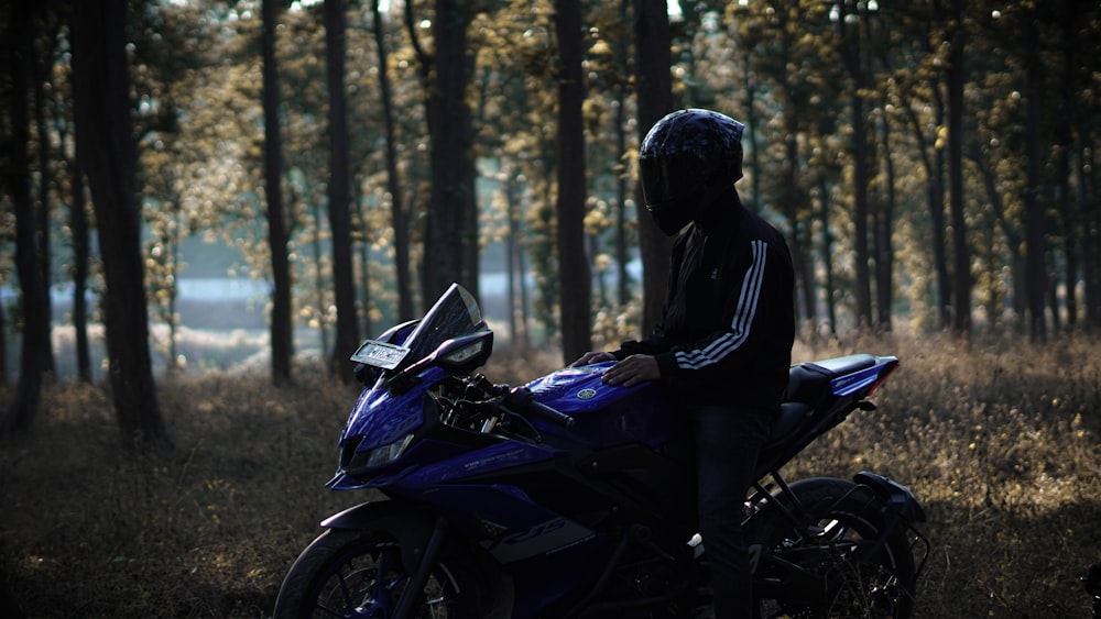 a person sitting on a motorcycle in the woods