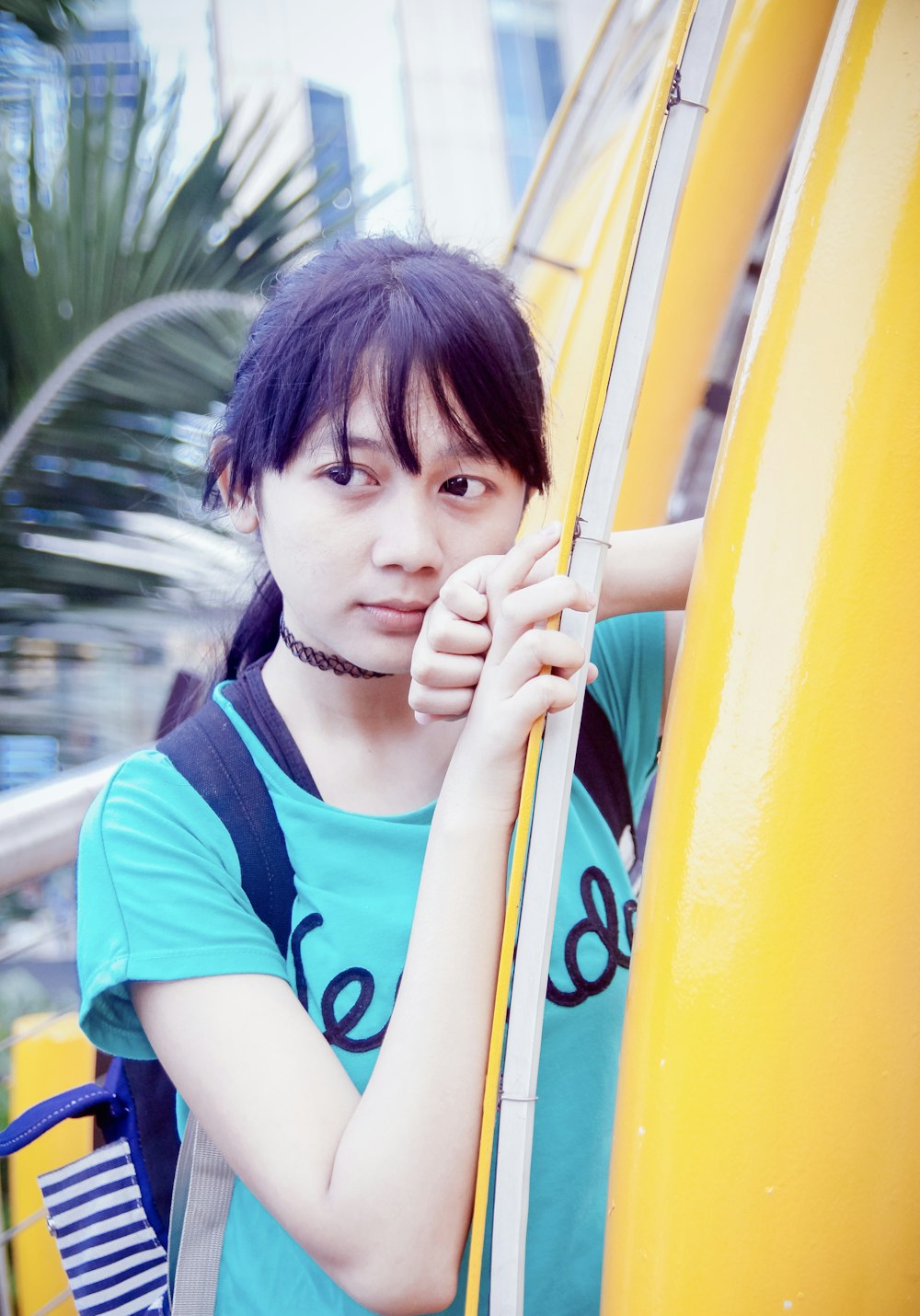 a young woman leaning against a yellow surfboard