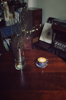 A cozy corner with an open coffee journal, a latte art cup, and soft beige textiles creating a calm atmosphere.