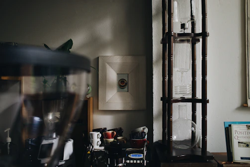 A sunlit urban apartment nook with a carefully arranged coffee setup and plants.