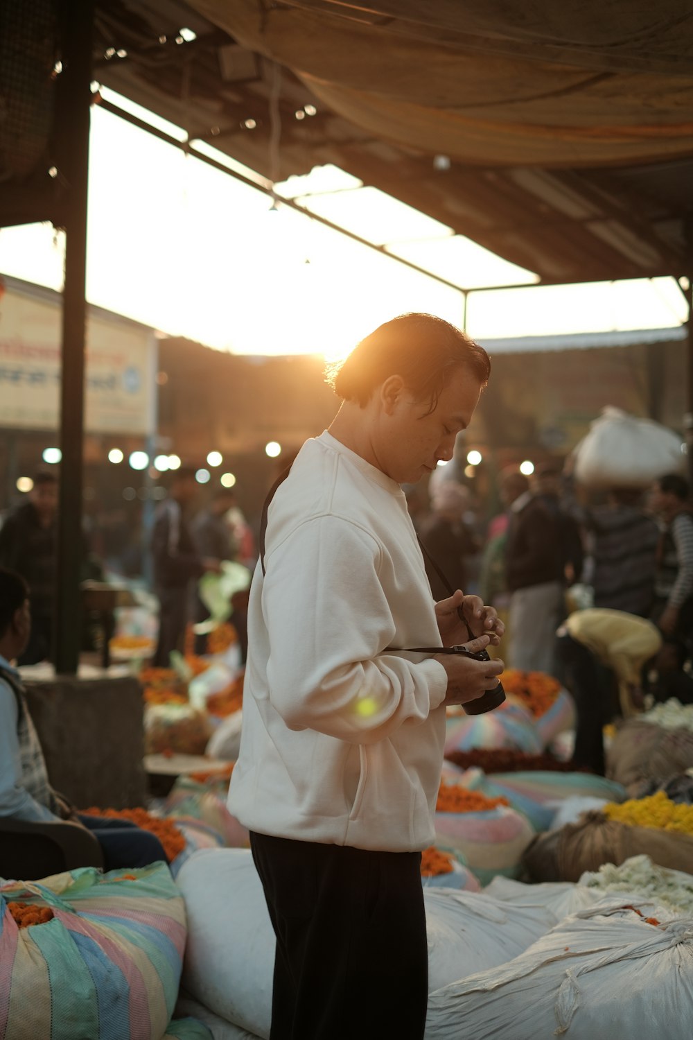 a man standing in a market looking at his cell phone