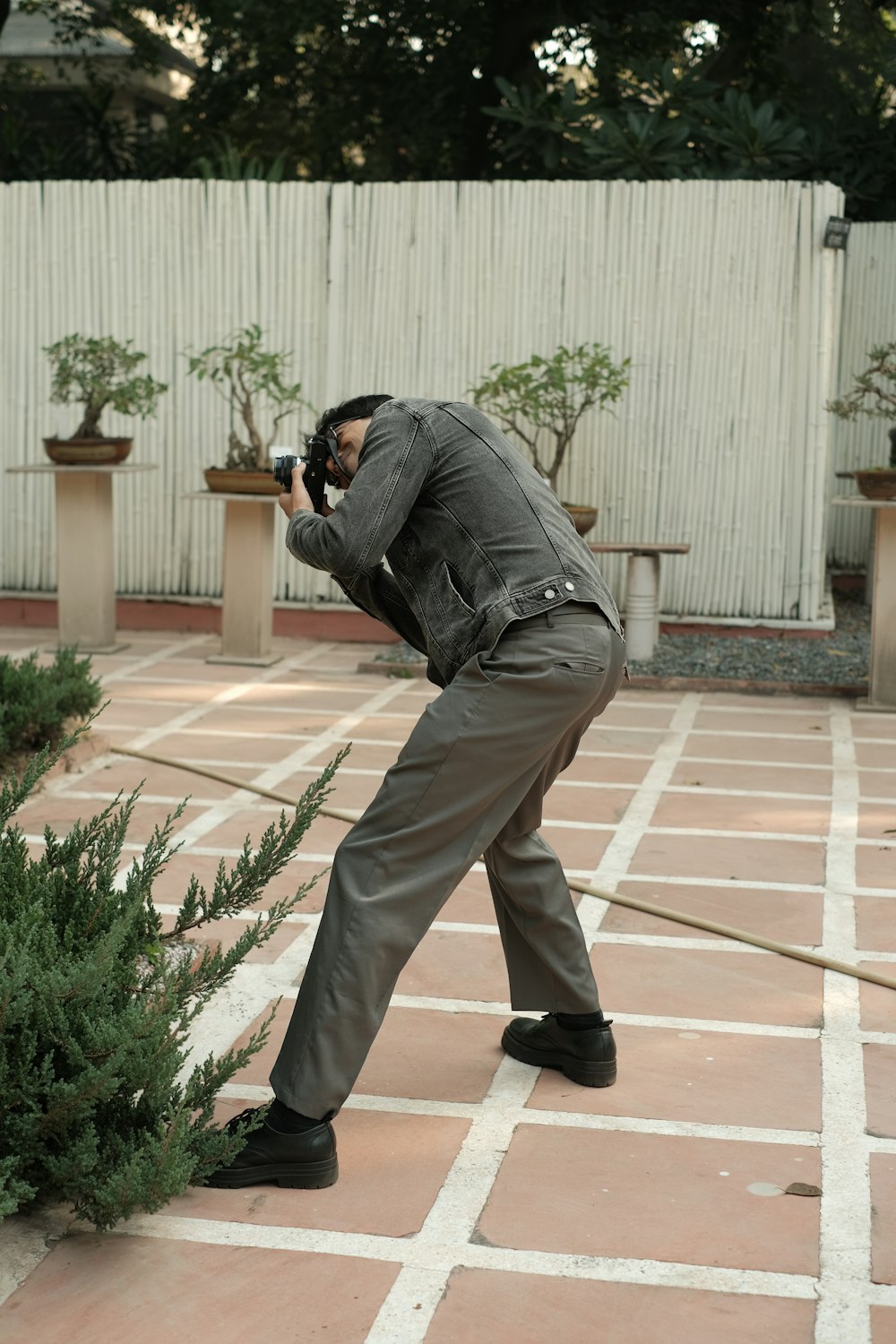 a man taking a picture of a plant with a camera