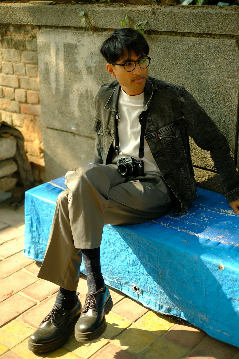 a man sitting on top of a blue bench