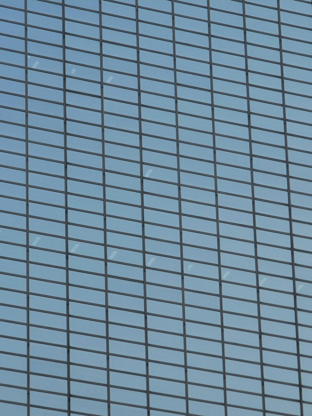 a plane flying in the sky behind a tall building