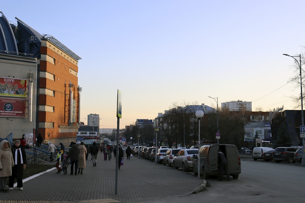 a group of people walking down a street next to tall buildings