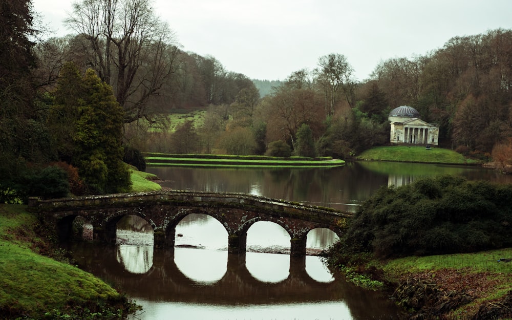 Un puente sobre un río con un edificio al fondo