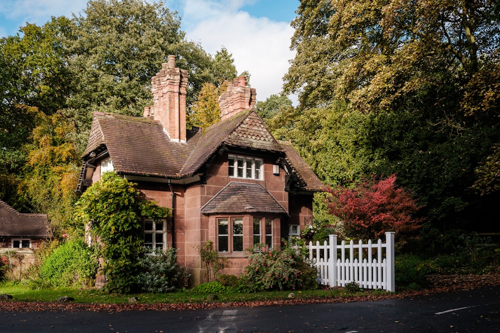 une maison avec une palissade blanche devant elle