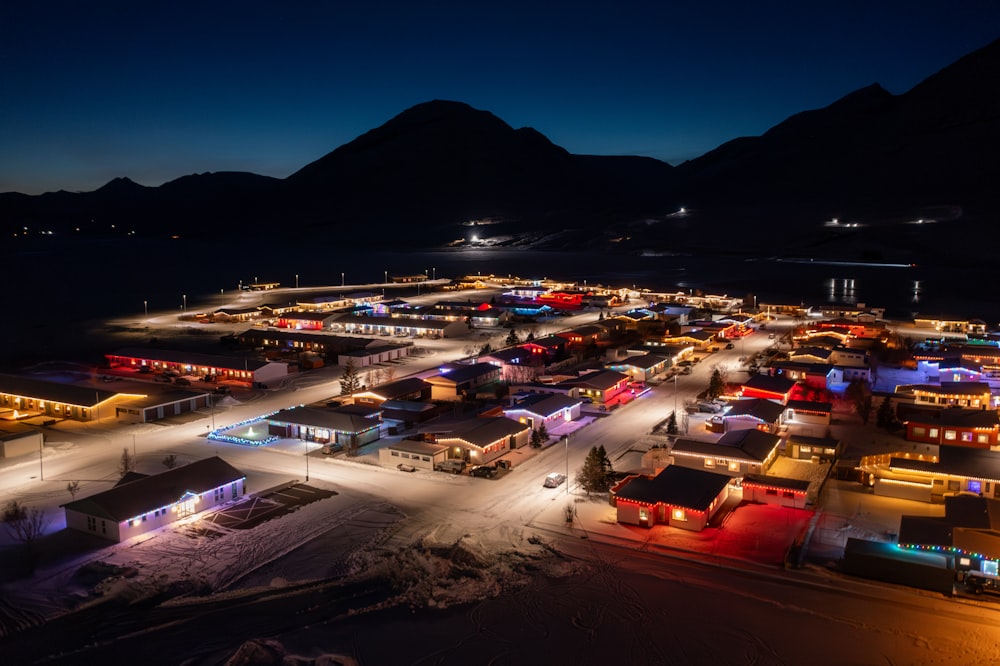 a night time view of a town with mountains in the background