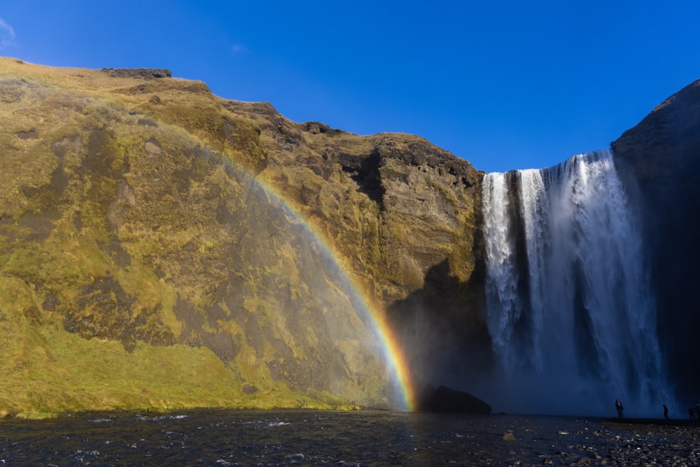 a waterfall with a rainbow in the middle of it