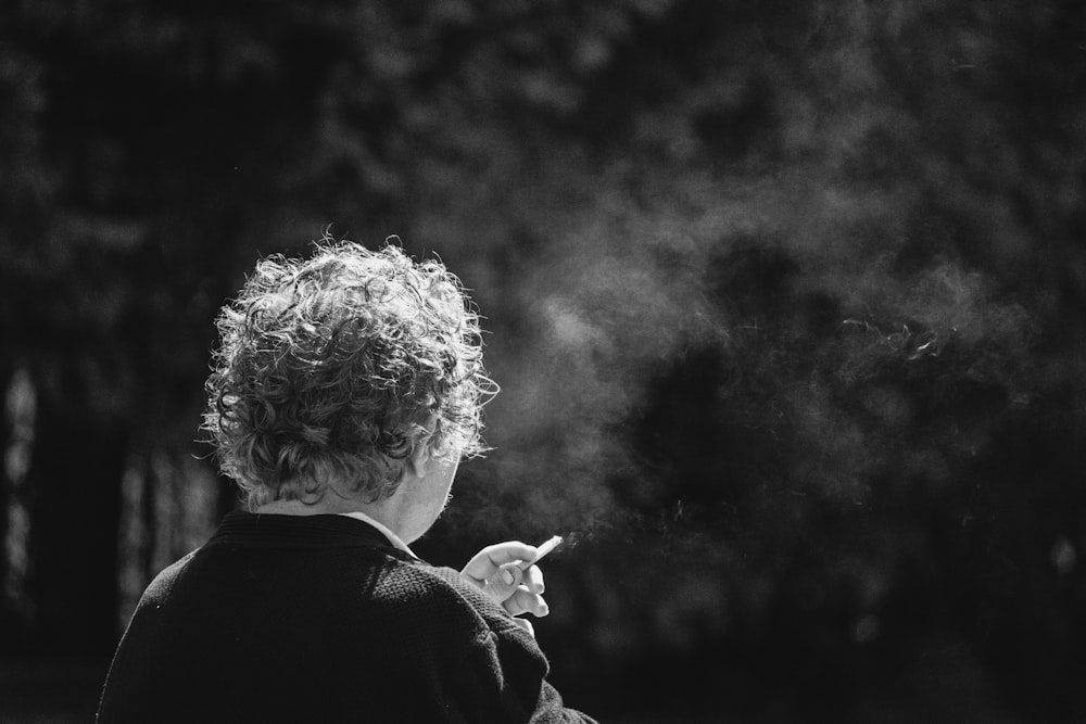 a woman smoking a cigarette in a black and white photo