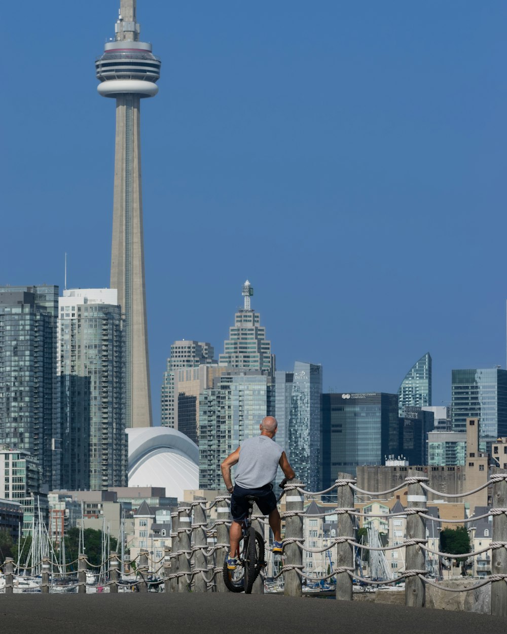 um homem andando de bicicleta em frente a uma cidade