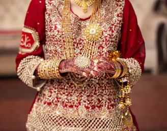 a woman in a red and gold wedding outfit