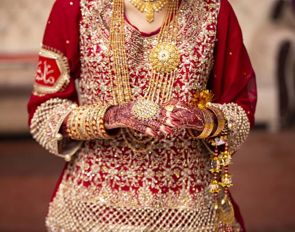 a woman in a red and gold wedding outfit