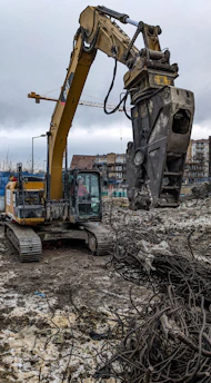 Technician welding a large excavator arm directly at a busy construction site in Bergen County.