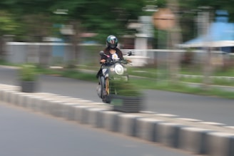 Motorcycle speeding on a winding road with a blurred background.