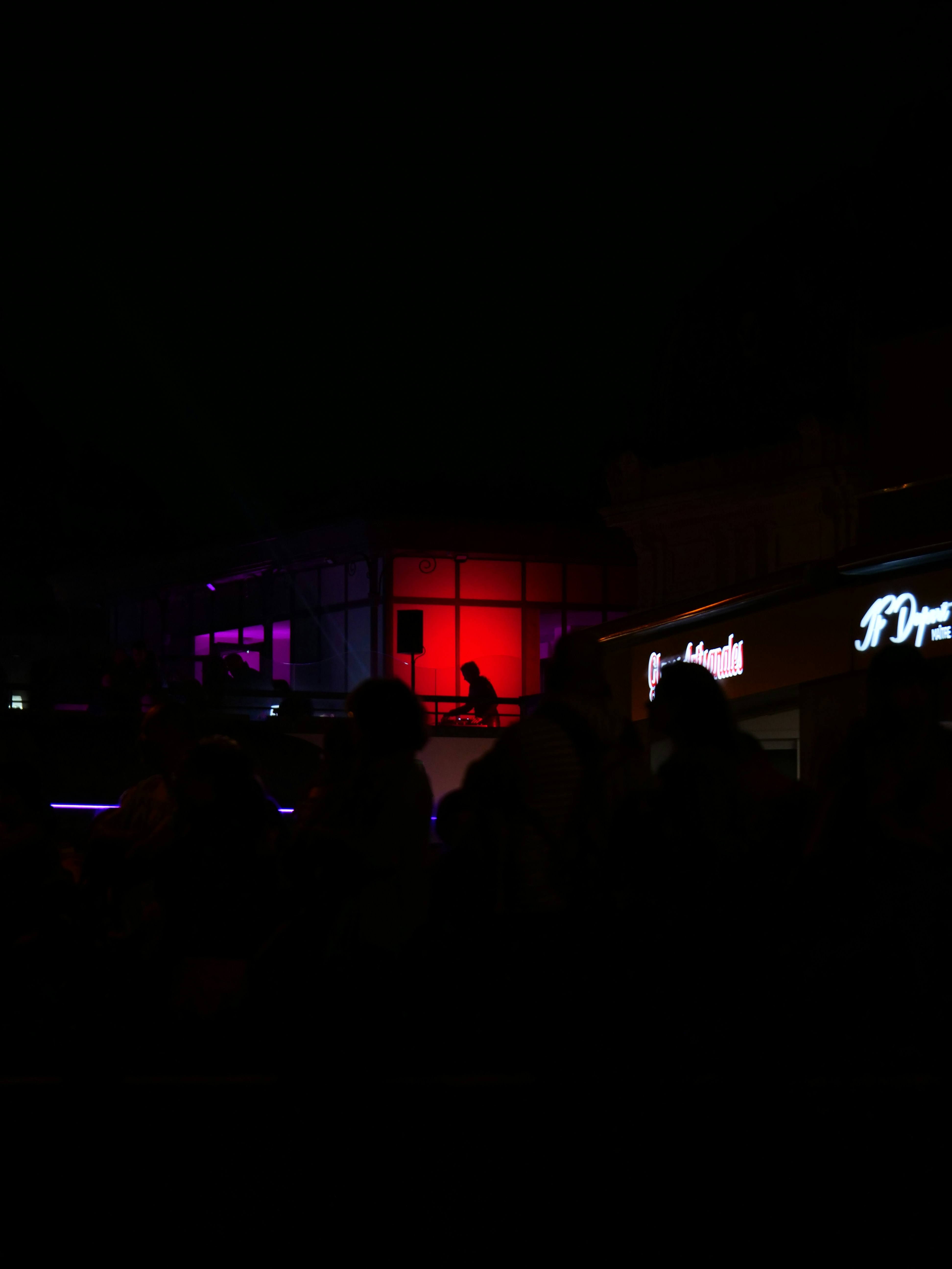 a group of people standing outside of a building at night