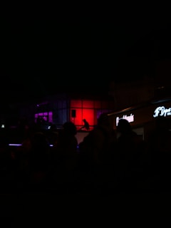 A detailed digital painting capturing a moody urban scene with glowing neon lights.