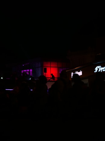 A detailed digital painting capturing a moody urban scene with glowing neon lights.