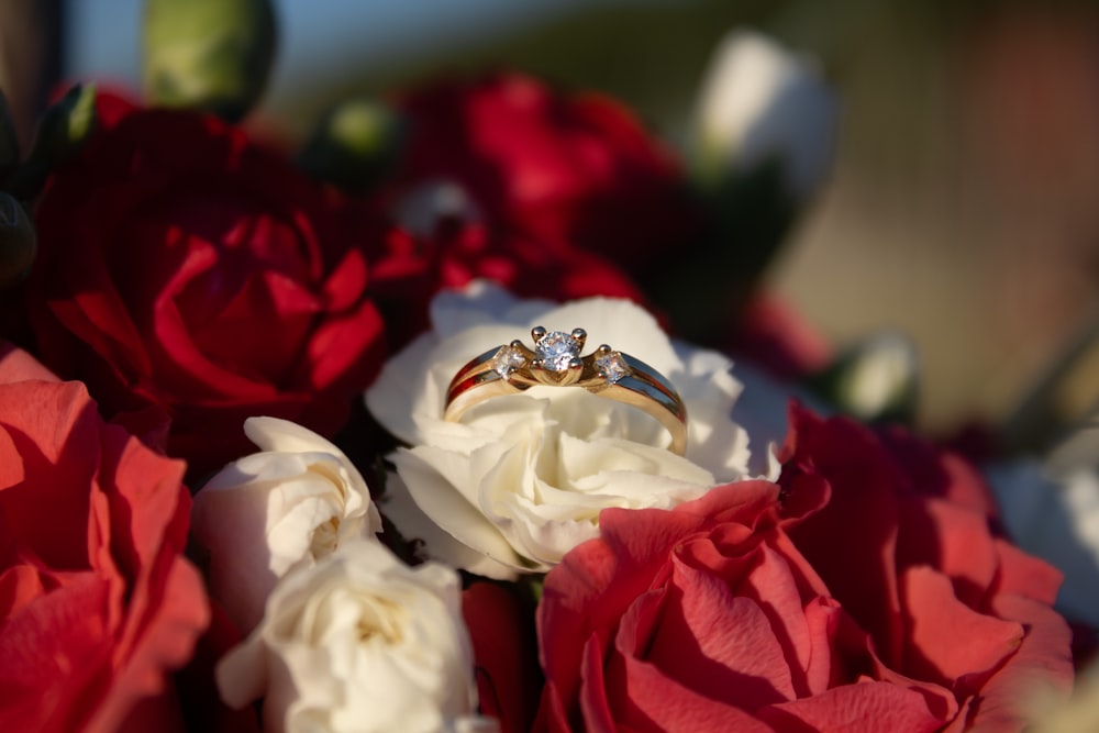 a couple of wedding rings sitting on top of a bouquet of flowers