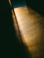 Golden afternoon light filtering through large windows onto a sleek marble counter lined with pastries.