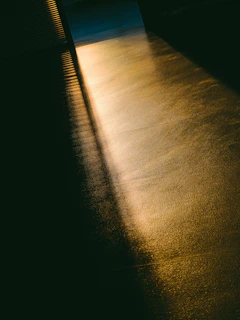 Golden afternoon light filtering through large windows onto a sleek marble counter lined with pastries.