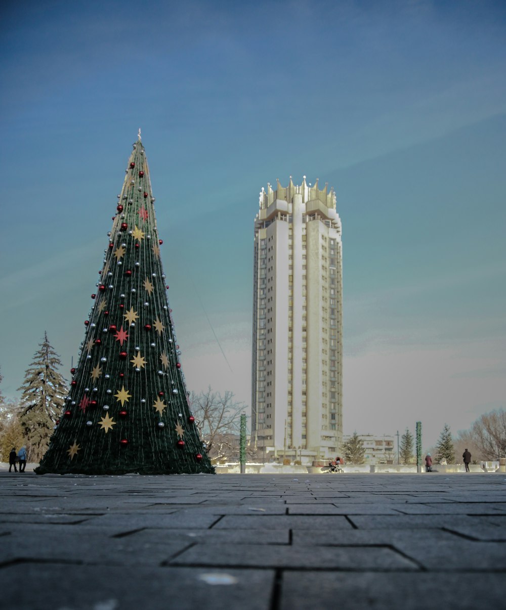 a large christmas tree sitting in front of a tall building