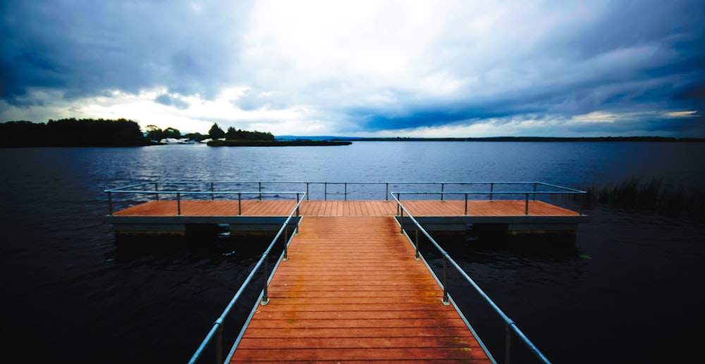 a dock on a body of water under a cloudy sky