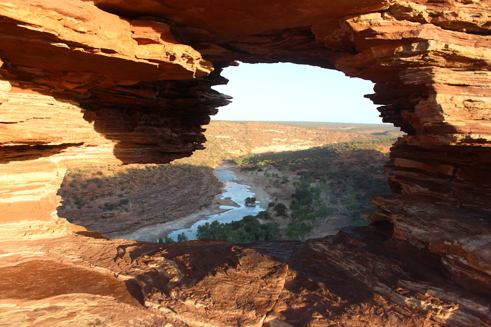a view of a river through a window in a rock formation