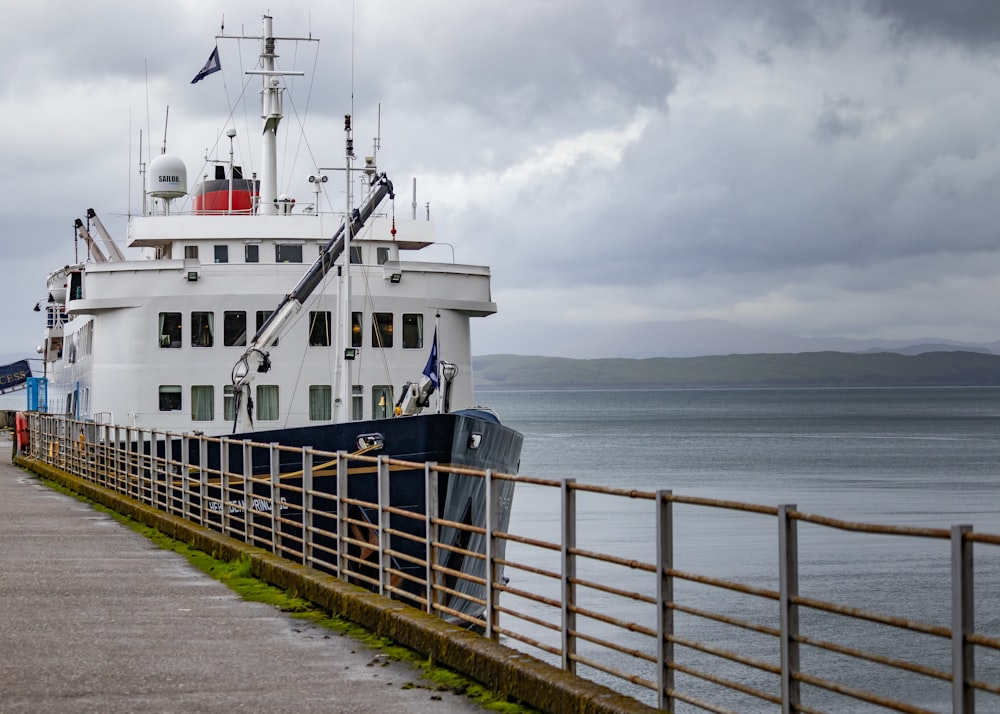 a large boat docked at a pier on a cloudy day