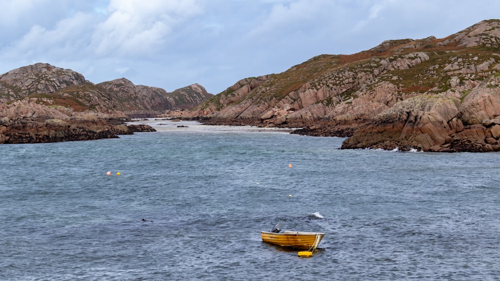 a small yellow boat floating on top of a body of water