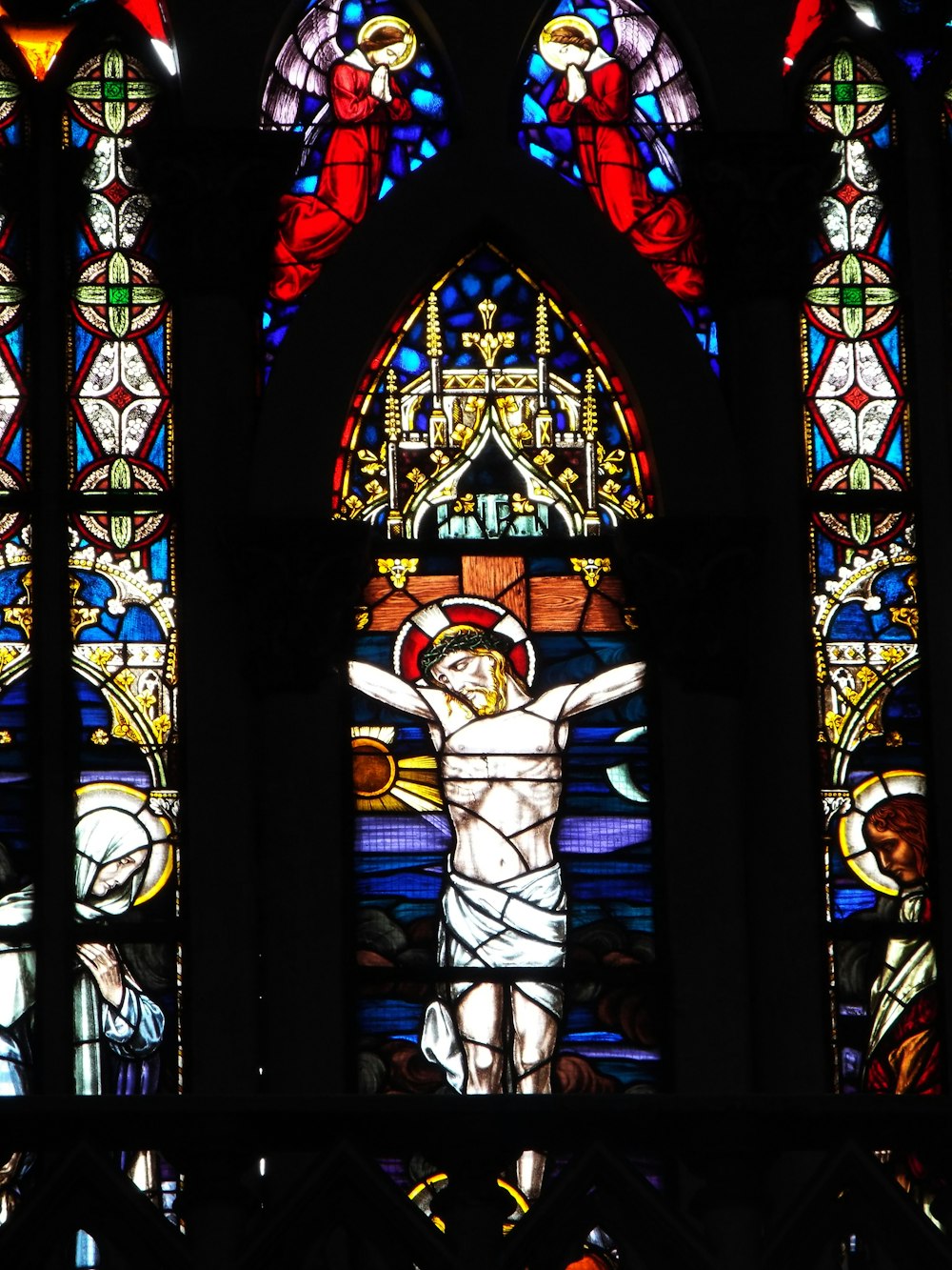 a stained glass window with a crucifix in it