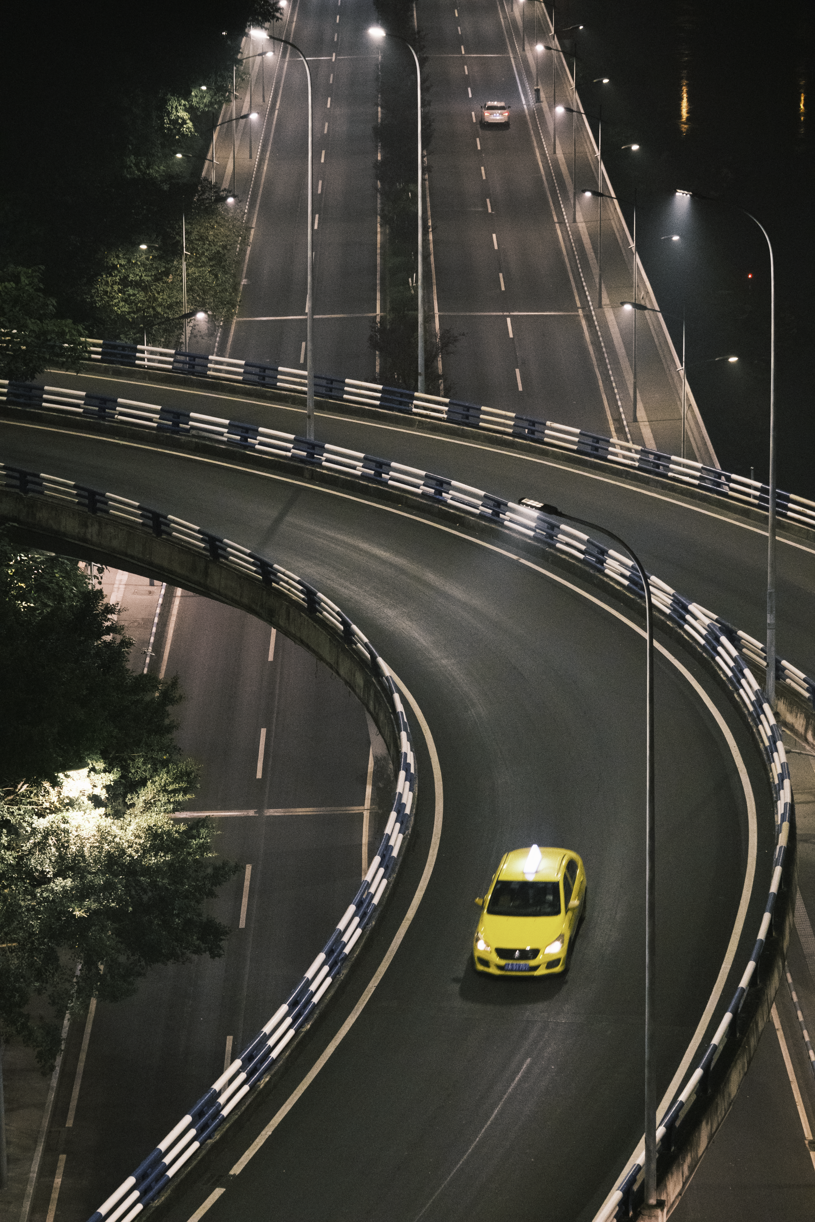 A yellow car driving down a highway at night photo – Free Car Image on ...
