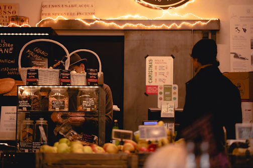 A cozy food market stall featuring artisanal breads and preserves, styled with crisp parchment and deep crimson details.
