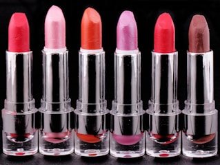 Vibrant lipsticks arranged in a gradient from soft pinks to deep reds.