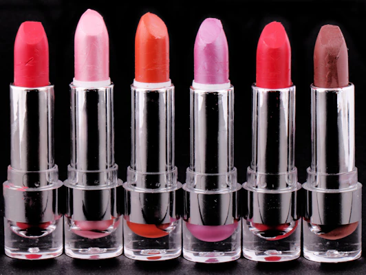 Close-up of vibrant lipsticks arranged in a gradient from bold reds to soft pinks.