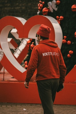 Model wearing a stylish Kwanzaa t-shirt standing against a festive backdrop with traditional decorations.