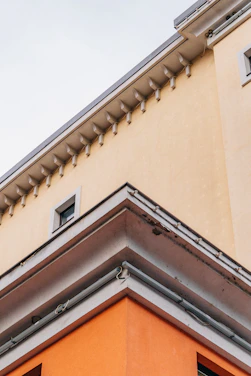 Close-up of a white EPS foam cornice with a smooth, reinforced coating installed on a modern building facade.