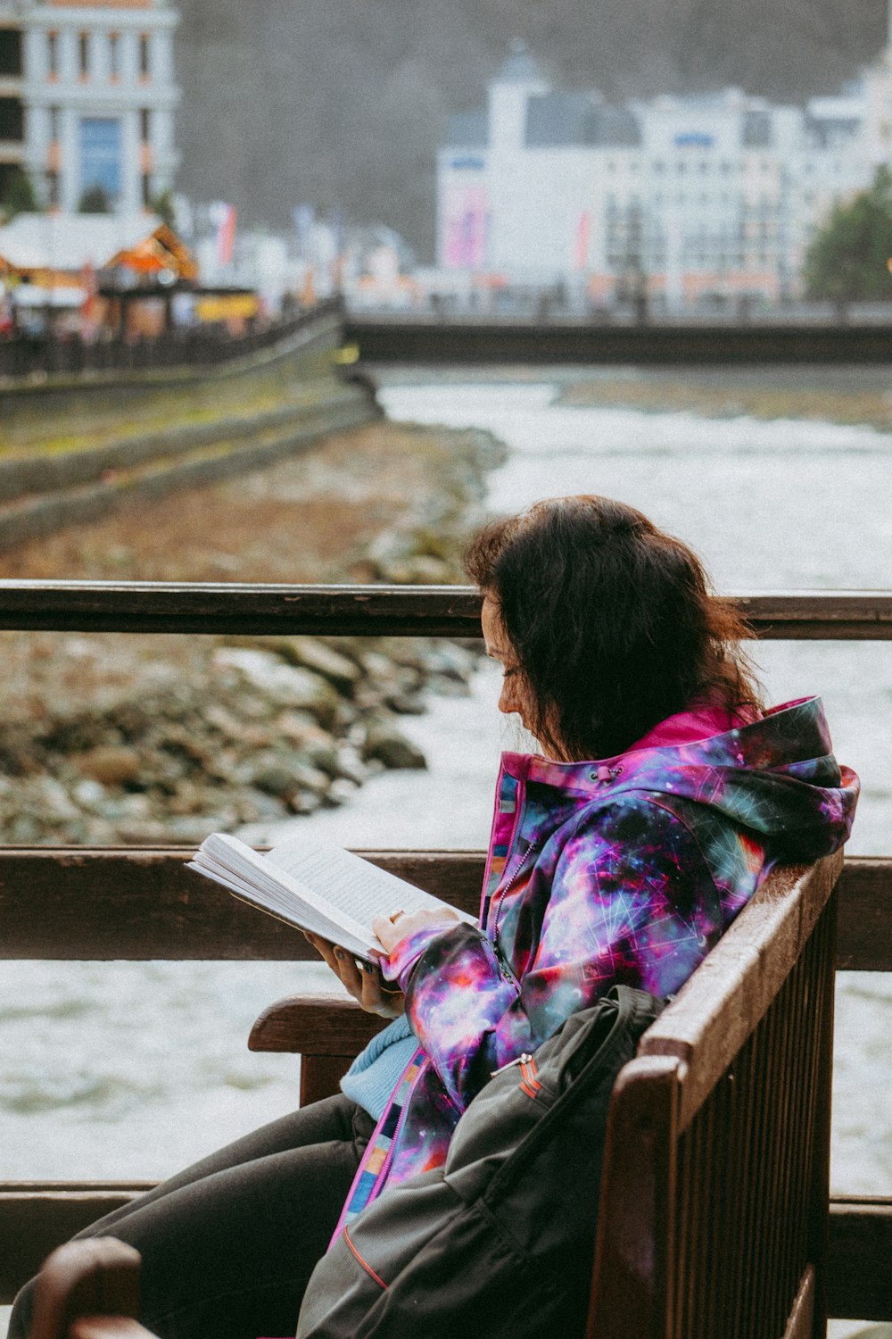 a woman sitting on a bench reading a book