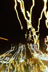 Abstract golden light trails flowing upward against a deep black background, symbolizing rising energy.